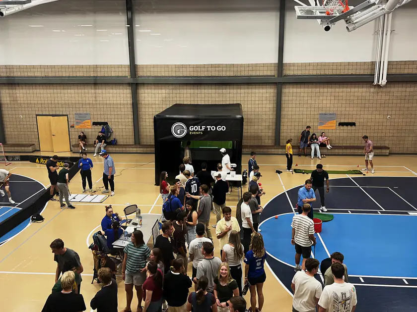 Crowd gathered around the Golf to Go Events mobile golf simulator at a South Jordan community event