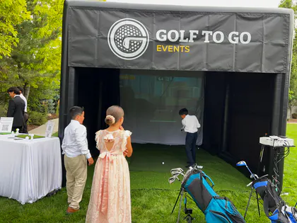 Guests watching a player inside the Golf to Go Events golf simulator tent at an American Fork, Utah event